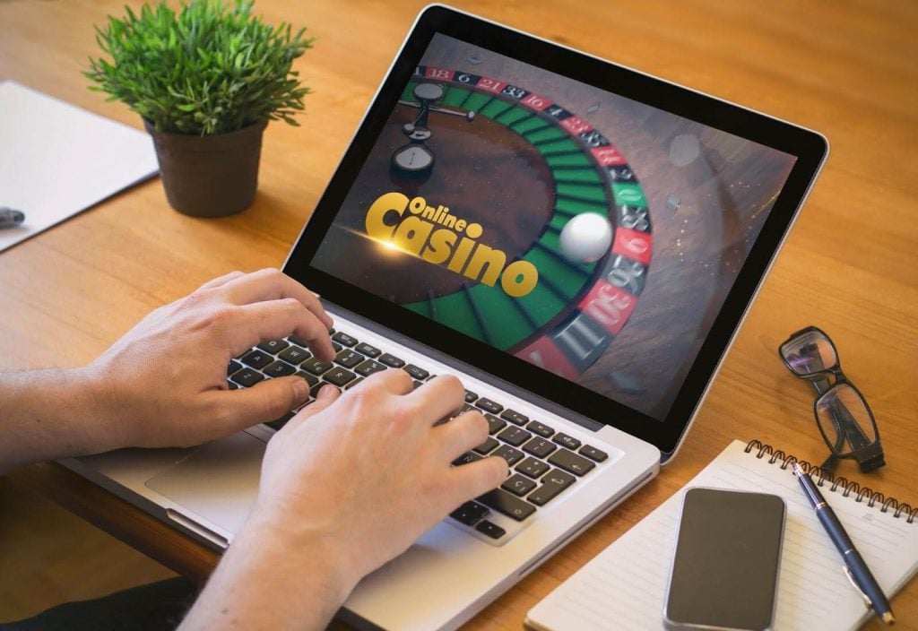 A man using his laptop to enter an online casino